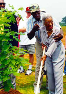 Ruth Owens, with the help of Thurman White, planting the Memorial Oak Tree at the Jesse Owens Museum.